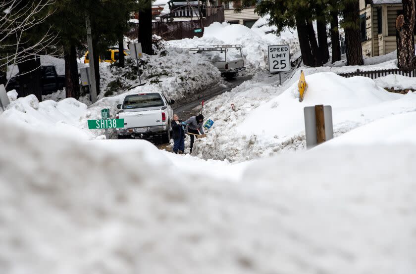 CRESTLINE, CA - MARCH 6, 2023: Deanna Beaudoin helps a neighbor shovel a shared driveway on March 6, 2023 in Crestline, California. They have been snowed-in for 12 days after recent storms dropped more than 100 inches of snow in the San Bernardino Mountains.(Gina Ferazzi / Los Angeles Times)