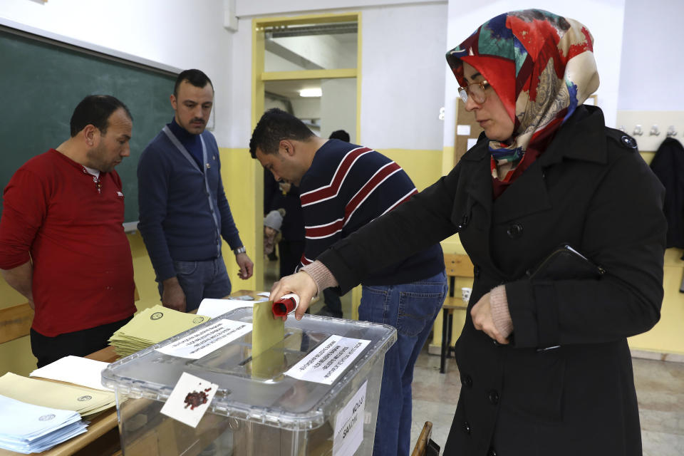 A woman cast her ballots at a polling station during the municipal elections in Ankara, Turkey, Sunday, March 31, 2019. Turkish citizens have begun casting votes in municipal elections for mayors, local assembly representatives and neighborhood or village administrators that are seen as a barometer of Erdogan's popularity amid a sharp economic downturn. (AP Photo/Ali Unal)