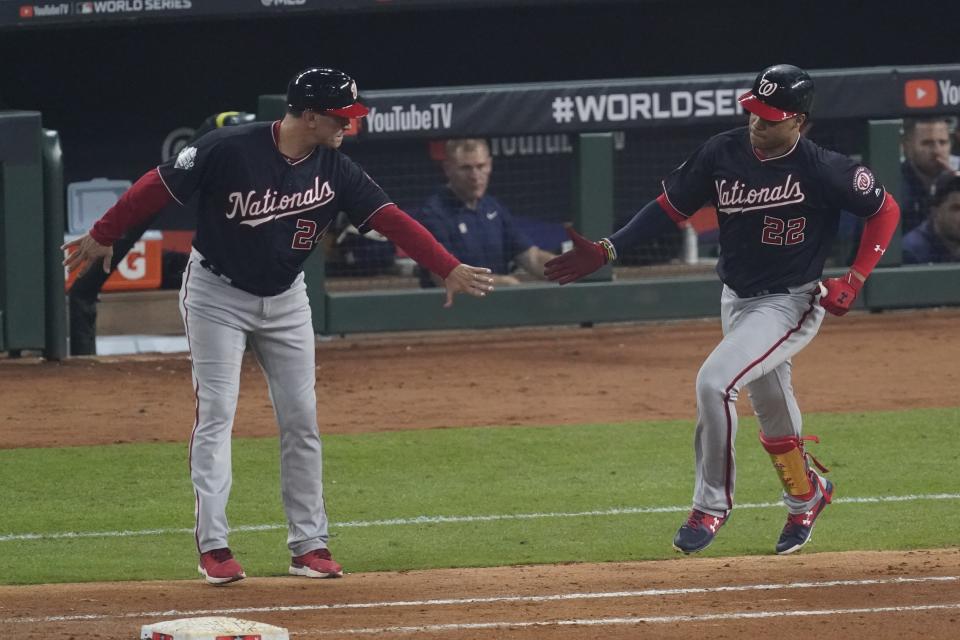 Washington Nationals' Juan Soto is congratulated by first base coach Tim Bogar after hitting a home run during the fourth inning of Game 1 of the baseball World Series against the Houston Astros Tuesday, Oct. 22, 2019, in Houston. (AP Photo/Eric Gay)