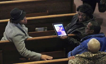 Mourners look at a photo of Tamir Rice before his funeral in Cleveland, Ohio December 3, 2014. REUTERS/Aaron Josefczyk
