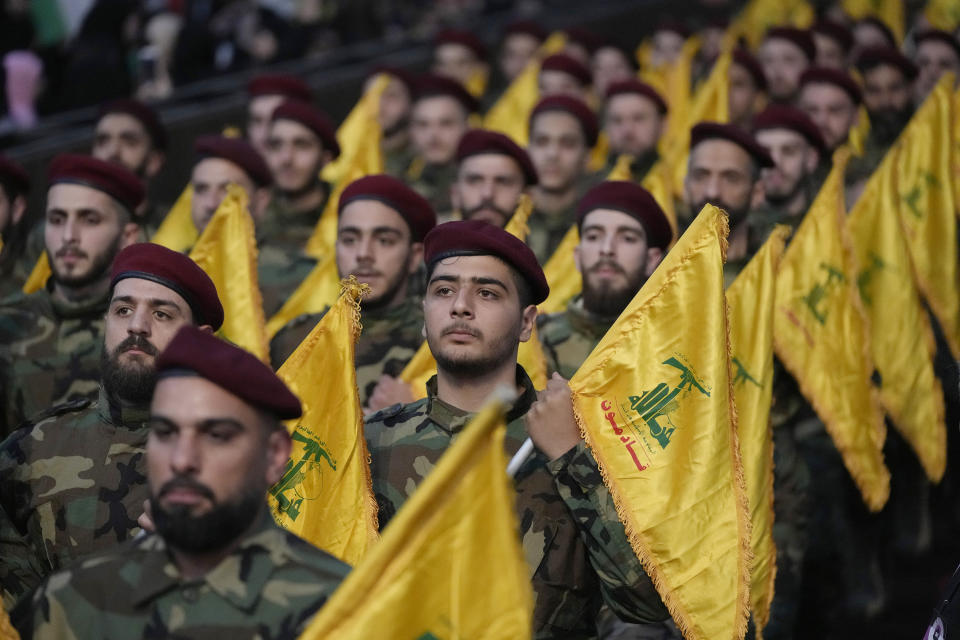 Hezbollah fighters hold their group flags, as they parade during a rally to mark Jerusalem day, in a southern suburb of Beirut, Lebanon, Friday, April 14, 2023. Since Iran's Islamic Revolution in 1979, the rallies marking what is also known as al-Quds Day have typically been held on the last Friday of the Muslim holy month of Ramadan. (AP Photo/Hussein Malla)