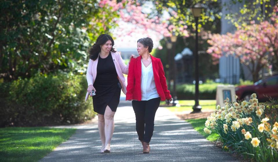 Washington state Rep. Michelle Caldier (left) holds the shoulder of her legislative assistant, Loujanna “LJ” Rohrer as they walk through the Capitol Campus in Olympia, Washington, on Wednesday, May 3, 2023. Caldier lost her eyesight to glaucoma 2016.