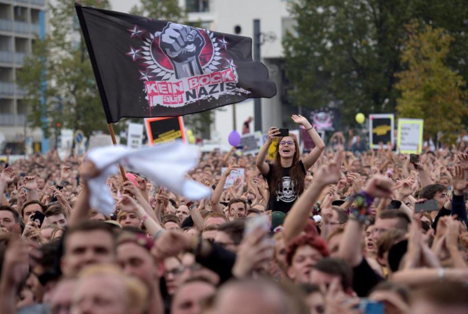 An anti-nazi flag flies among crowds in Chemnitz (EPA)