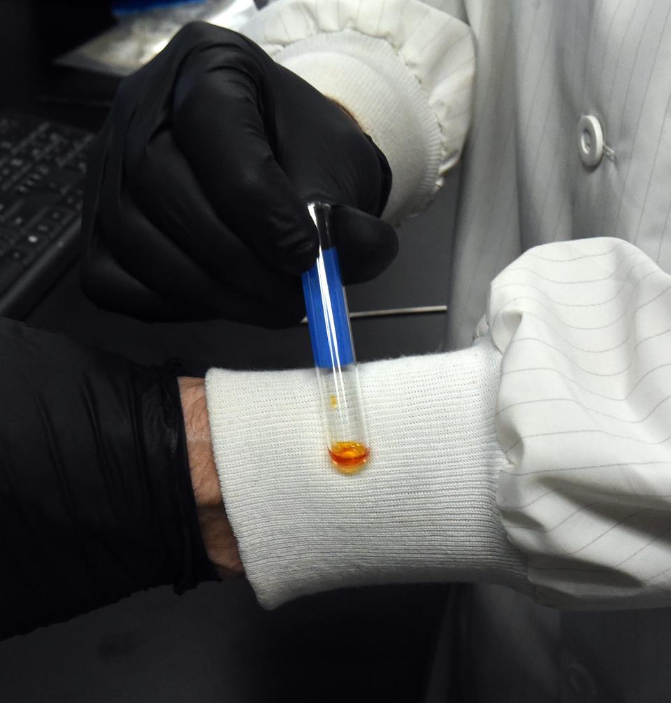 Mark Hiatt, lab director of the Licking County Sheriff's Office Crime Lab, shows a sample of a substance after it is mixed with a reagent. The substance turned a rich organ-red indicating the presence of methamphetamines.