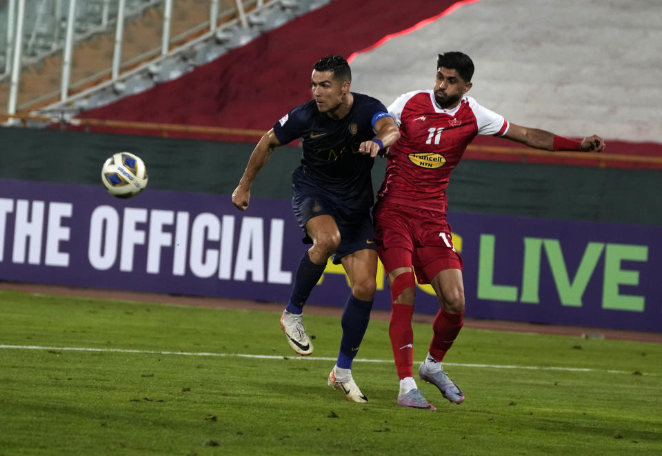 Al Nassr's Cristiano Ronaldo, left, vies for the ball with Iran's Persepolis Danial Esmaeilifar during their AFC Champions League soccer match at the Azadi Stadium in Tehran, Iran, Tuesday, Sept. 19, 2023. (AP Photo/Vahid Salemi)