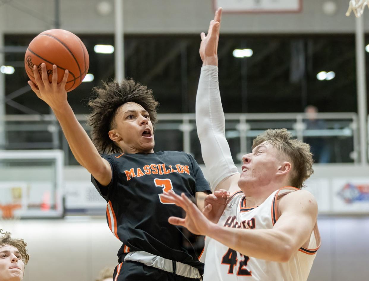 Massillon’s Chris Knight goes to the basket over Hoover’s Mason Bille on Friday, Jan. 6, 2023.