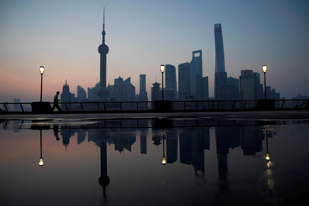 A security guard walks on the bund in front of the financial district of Pudong in Shanghai, China