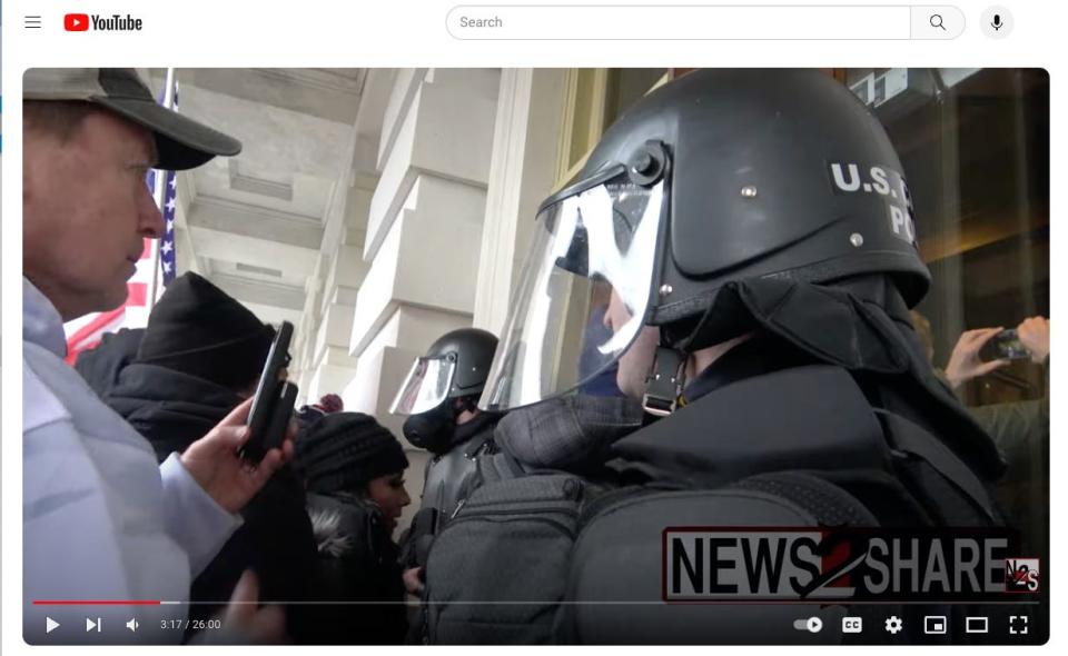 Video shot by a freelance journalist shows the woman in the black beanie crowding past a police officer and into the Capitol on Jan. 6, 2021.