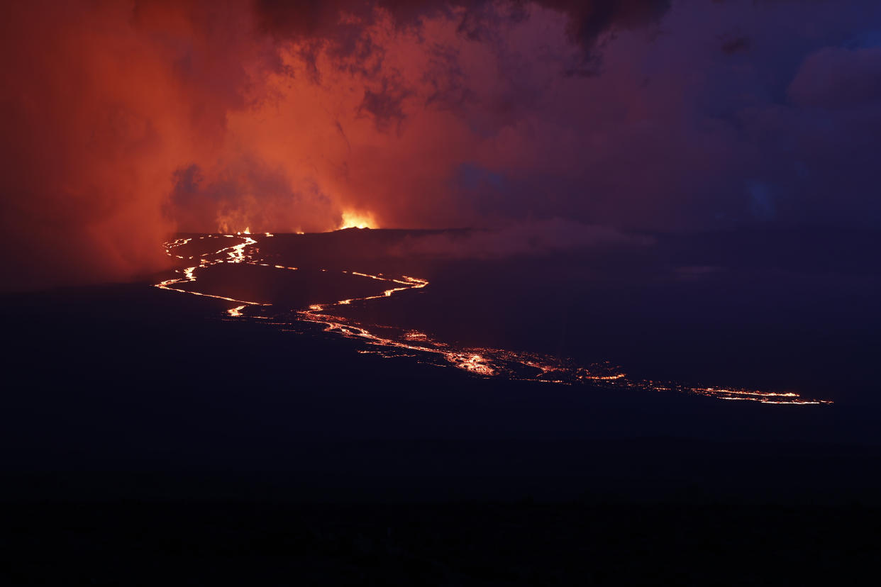 Lava flows down the mountain from the Mauna Loa eruption, Tuesday, Nov. 29, 2022, near Hilo, Hawaii. (AP Photo/Marco Garcia)