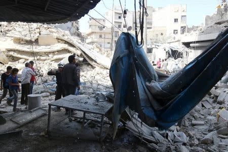 People inspect the damage at a market hit by air strikes in Aleppo's rebel-held al-Fardous district, Syria October 12, 2016. REUTERS/Abdalrhman Ismail