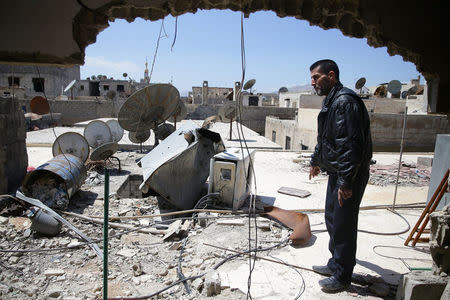 Abu Ghassan, 50, one of the survivors of a chemical attack in the Ghouta region of Damascus that took place in 2013, points at a piece of one of the rockets fired in 2013, as he stands in the Ghouta town of Ain Tarma, Syria April 7, 2017. REUTERS/Bassam Khabieh