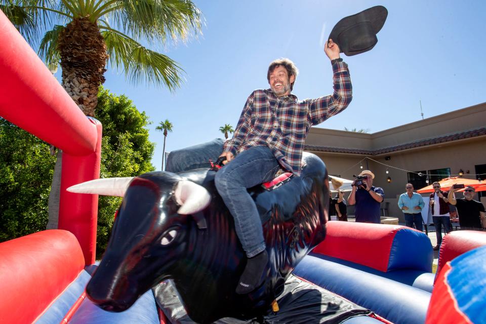 Jason Gurzi, Integrated Marketing Manager for the Coachella Valley Firebirds rides a mechanical bull during an event held by Acrisure Arena at  The Cantina in Indio, Calif., on Monday, September 26, 2022. Announcements were made for five more events including one for the Professional Bull Riders. 