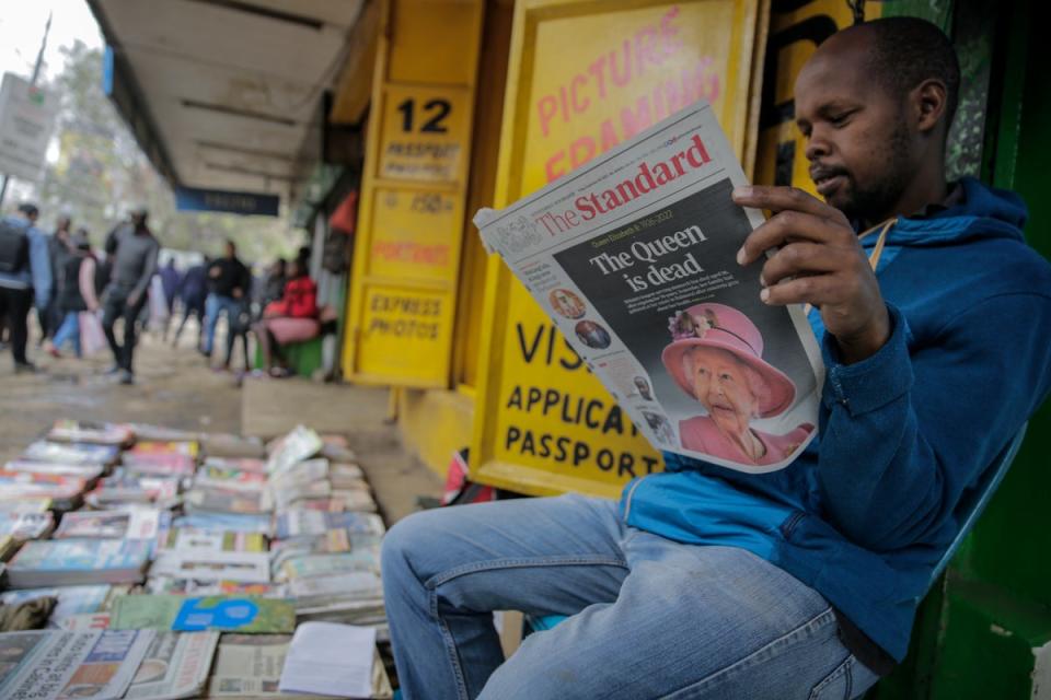 A vendor reads a paper showing coverage of the death of Queen Elizabeth II in Nairobi, Kenya (AP)