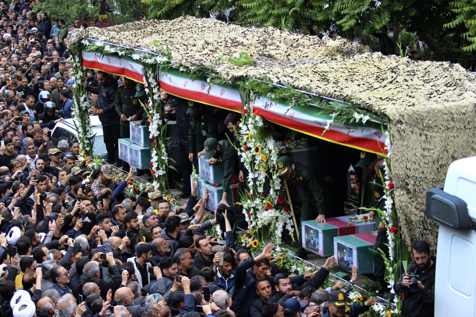 In this photo provided by Fars News Agency, mourners gather around a truck carrying coffins of Iranian President Ebrahim Raisi and his companions who were killed in their helicopter crash on Sunday in a mountainous region of the country's northwest, during a funeral ceremony at the city of Tabriz, Iran, Tuesday, May 21, 2024. Mourners in black began gathering Tuesday for days of funerals and processions for Iran's late president, foreign minister and others killed in a helicopter crash, a government-led series of ceremonies aimed at both honoring the dead and projecting strength in an unsettled Middle East. (Ata Dadashi, Fars News Agency via AP)