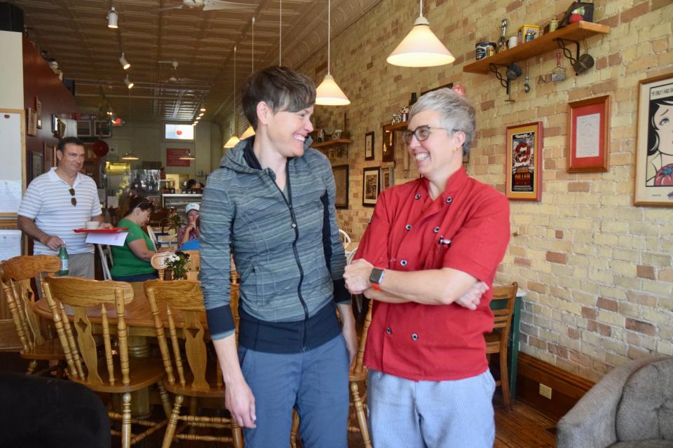 Julienne Tomatoes owner Julie Adams (right) and manager Cally Plummer (left) stand in the dining room of the reopened restaurant after being closed for two months due to flood damage from a sewer backup.