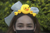 A protester wears a head band designed with yellow ducks, which have become good-humored symbols of resistance during anti-government rallies, on Wednesday, Nov. 25, 2020, in Bangkok, Thailand. Thai authorities have escalated their legal battle against the students leading pro-democracy protests, charging 12 of them with violating a harsh law against defaming the monarchy. (AP Photo/Wason Wanichakorn)