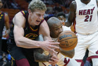 Cleveland Cavaliers forward Lauri Markkanen, left, and Miami Heat forward P.J. Tucker scramble for a loose ball during the first half of an NBA basketball game, Wednesday, Dec. 1, 2021, in Miami. (AP Photo/Wilfredo Lee)