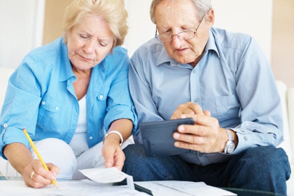 Portrait of a retired senior couple calculating their personal finances at home