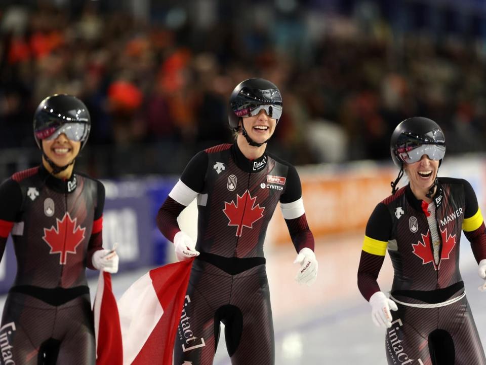 Canadians Brooklyn Mcdougall, Carolina Hiller and Ivanie Blondin celebrate their win in the team sprint at the world speed skating championships in Netherlands. (Dean Mouhtaropoulos/Getty Images - image credit)