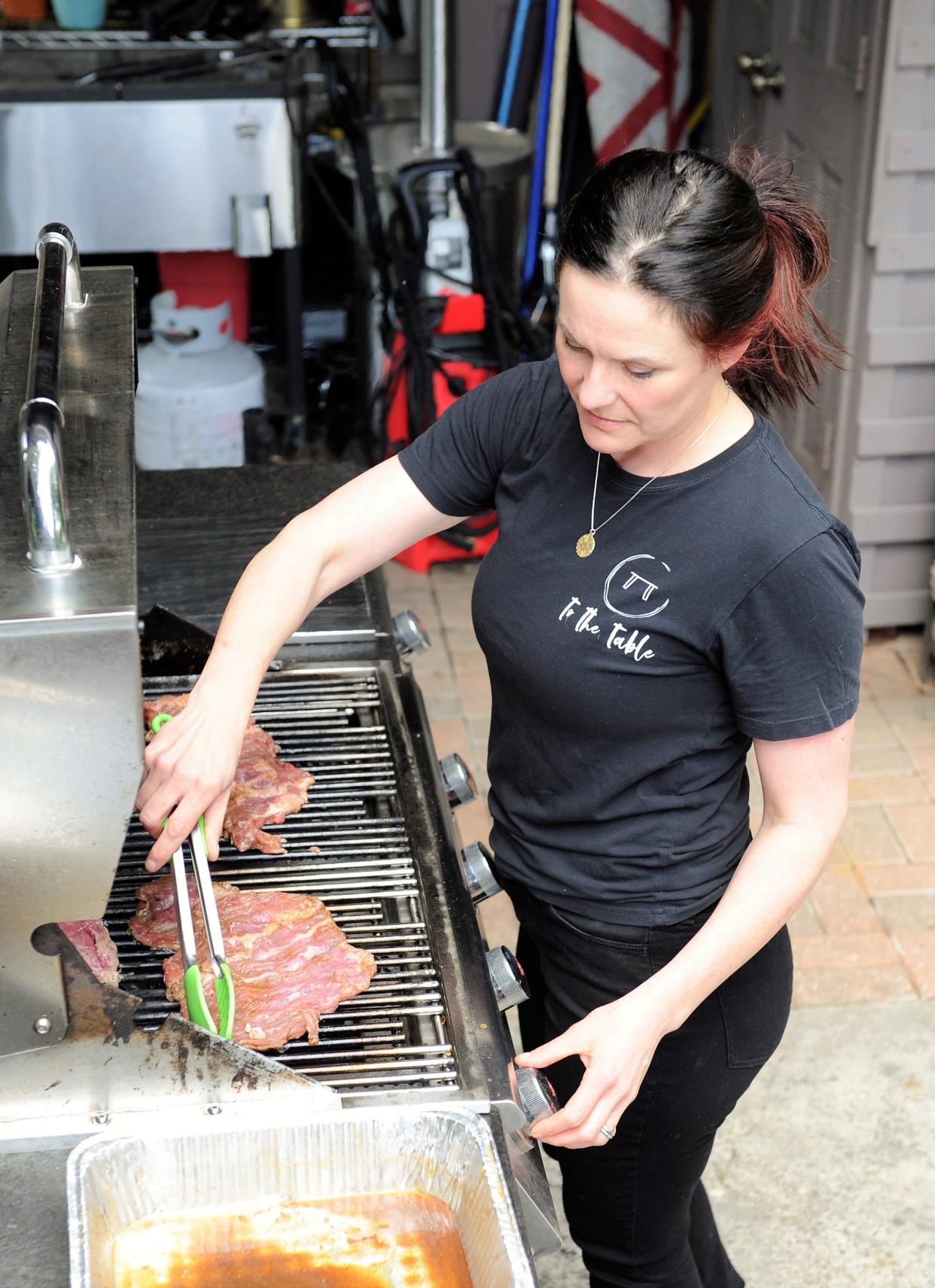 Lexie Fankhouser of To the Table grills skirt steak to slice for sandwiches on Tuesday, May 9, 2023.