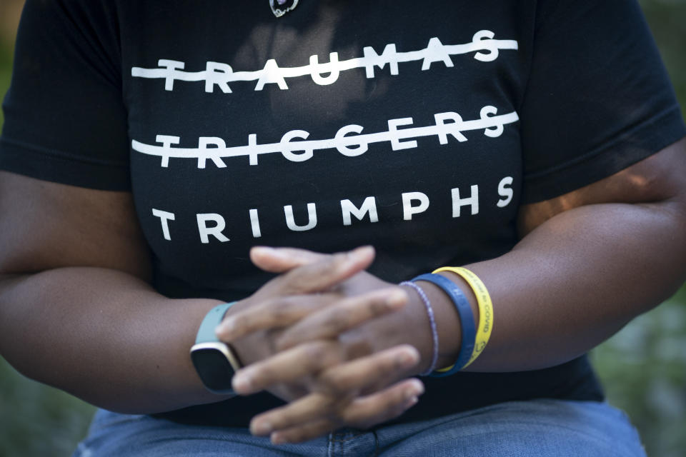 Melanese Marr-Thomas wears a T-shirt printed with the motivational words "Traumas, Triggers, Triumphs" at home in District Heights, Md., on Wednesday, Sept. 21, 2022. It’s been two years since the death of her husband, Charles, and the family has worked hard together, and in their own ways, to keep his memory alive. (AP Photo/Wong Maye-E)