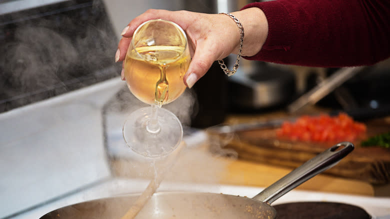 wine being poured into pan on stove