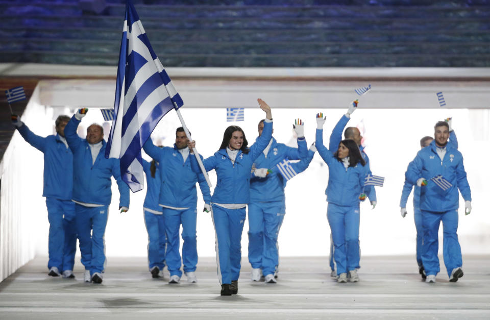 Panagiota Tsakiri of Greece carries the national flag as she leads the team during the opening ceremony of the 2014 Winter Olympics in Sochi, Russia, Friday, Feb. 7, 2014. (AP Photo/Mark Humphrey)