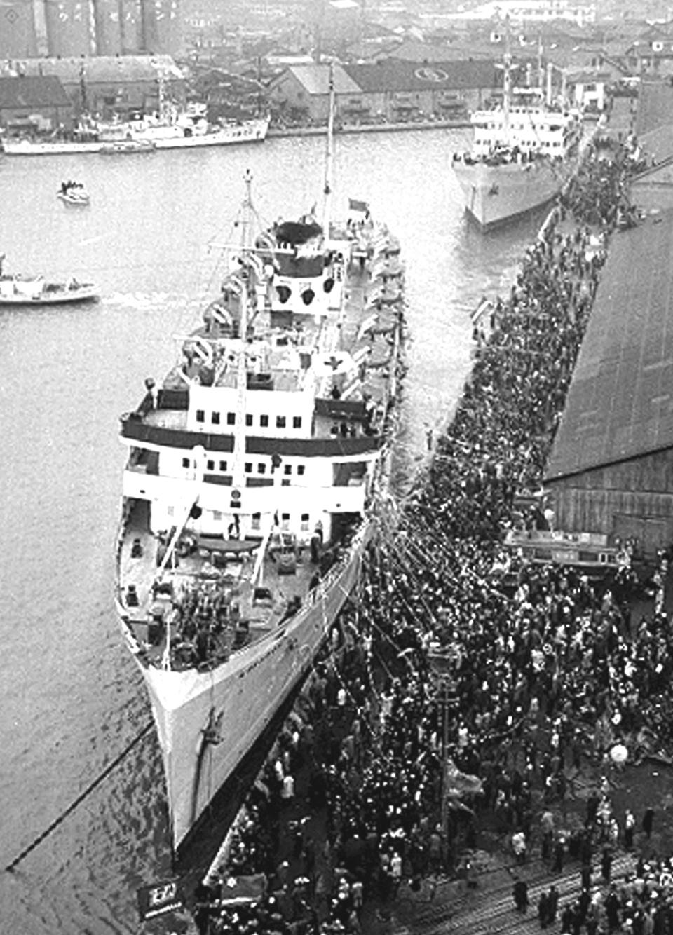 In this Dec. 14, 1959, photo, the first two ships carrying 975 people depart for North Korea from the port of Niigata, Japan, after receiving a grand see-off. A Japanese court has summoned North Korea's leader to face demands for compensation by several ethnic Korean residents of Japan who say they suffered human rights abuses in North Korea after joining a resettlement program there that described the country as a “paradise on Earth,” a lawyer and plaintiff said Tuesday. (Kyodo News via AP)