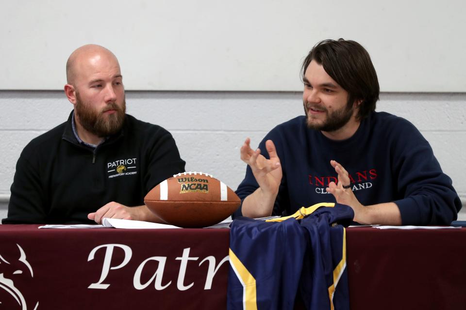 Assistant football coaches Jordan Flory (left) and Sam Vavzincak speak to students and parents at a meet-and-greet May 24 for Patriot Prep's new football program.