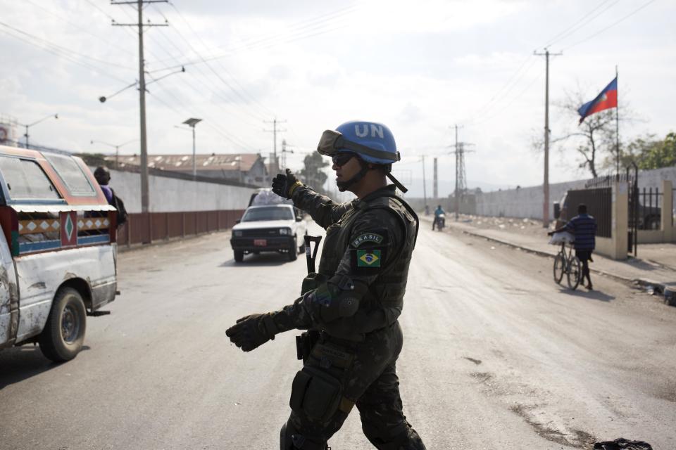 In this Feb. 22, 2017 photo, a U.N. peacekeeper from Brazil directs traffic in the Cite Soleil slum, in Port-au-Prince, Haiti. For years, uniformed U.N. personnel provided the only real security here. But these days, Haiti's police do most of the heavy lifting. (AP Photo/Dieu Nalio Chery)