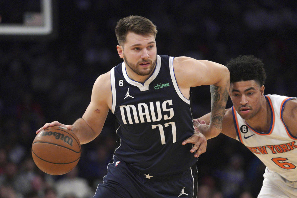 Dallas Mavericks guard Luka Doncic, left, drives the lane around New York Knicks guard Quentin Grimes, center, during the first quarter of an NBA basketball game, Saturday, Dec. 3, 2022, in New York. (AP Photo/Bebeto Matthews)