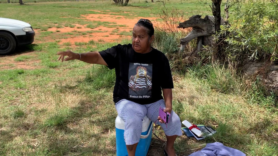 Sheryl Nichols points to her right. She sits on an esky near the Pilliga bore.