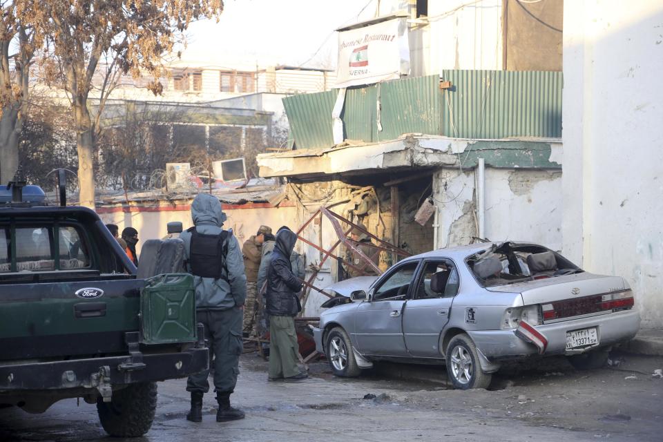 Afghan security forces personnel investigate at the site of the Friday's suicide attack and shooting, in Kabul, Afghanistan, Saturday, Jan. 18, 2014. A Taliban suicide bomber and two gunmen on Friday attacked a Lebanese restaurant that is popular with foreigners and affluent Afghans in Kabul, a brazen attack that left 16 dead, including foreigners dining inside and two other gunmen, officials said. (AP Photo/Rahmat Gul)