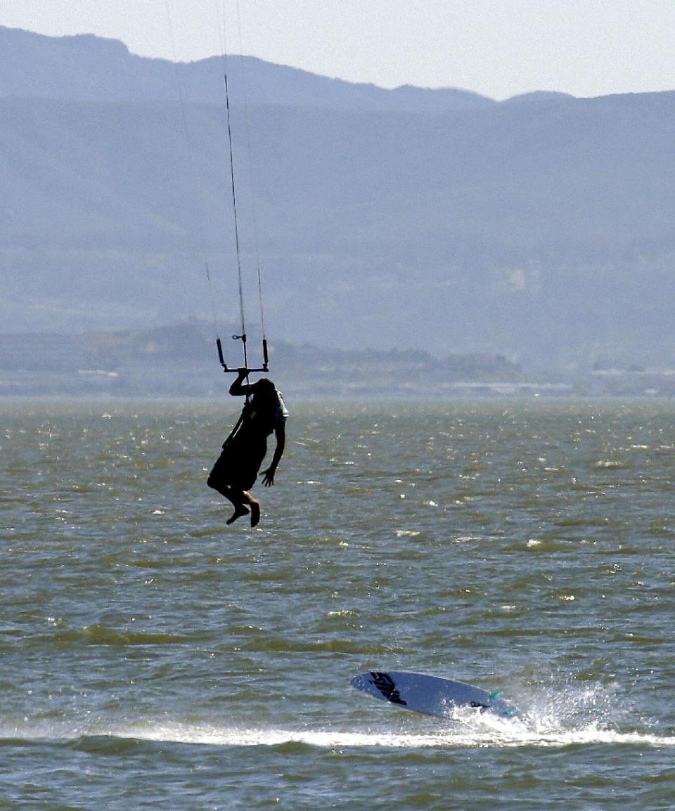 A wind surfer loses his board Monday, May 12, 2014, off Crown Memorial Beach in Alameda, Calif. After a hot, windy Mother's Day with temperatures in the mid-80s, a high pressure system was expected to heighten the heat slightly Monday before pushing it to near triple digits in some spots midweek, mostly inland areas already badly parched by drought. High temperatures will extend up and down California, according to the National Weather Service. (AP Photo/Ben Margot)