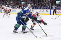 Vancouver Canucks' Bo Horvat (53) skates with the puck past Calgary Flames' Oliver Kylington (58), of Sweden, during the second period of an NHL hockey game Saturday, Feb. 8, 2020, in Vancouver, British Columbia. (Darryl Dyck/The Canadian Press via AP)