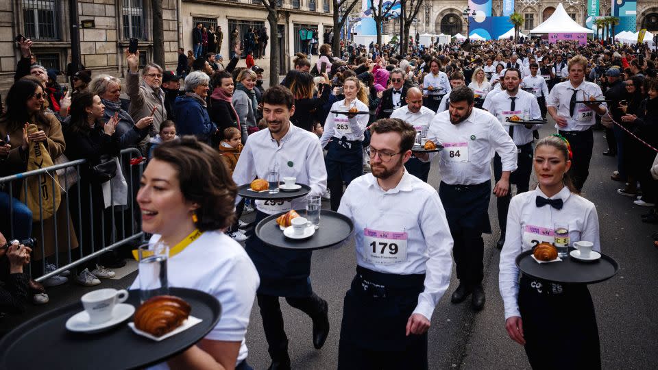 Waiters start the Course des Cafes race on March 24, 2024. - Dimitar Dilkoff/AFP/Getty Images