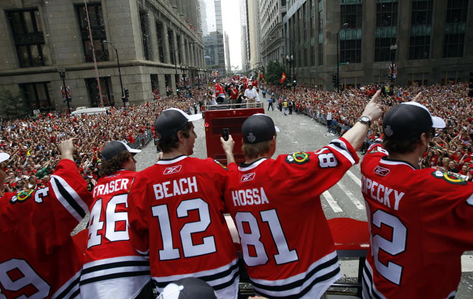 Chicago Blackhawks' Cristobal Huet, Colin Fraser, Kyle Beach, Marian Hossa and Tomas Kopecky (L-R) take part in a parade to honor the winners of the NHL's Stanley Cup hockey championship in Chicago June 11, 2010. Two million fans turned out to celebrate the Chicago Blackhawks' National Hockey League championship with a ticker-tape parade on Friday, roaring their approval of the team's first Stanley Cup in half a century. REUTERS/Jeff Haynes (UNITED STATES - Tags: SPORT ICE HOCKEY IMAGES OF THE DAY)