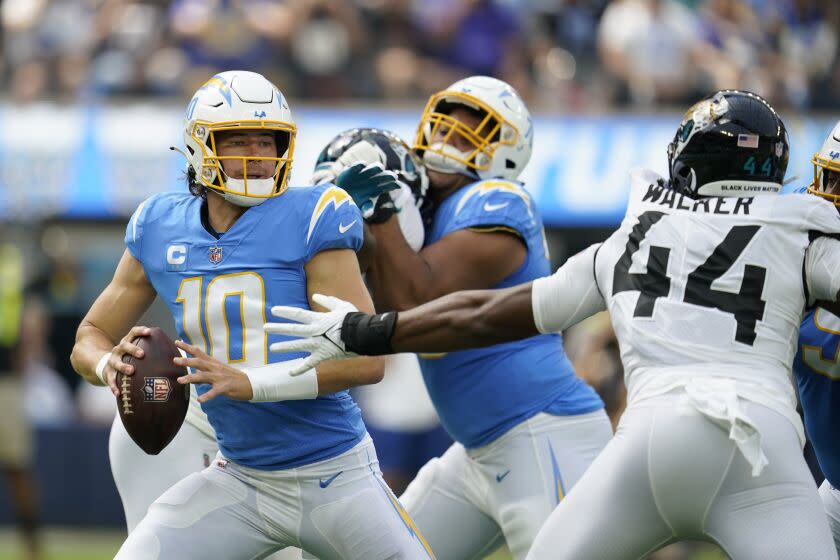 Los Angeles Chargers quarterback Justin Herbert (10) is pressured by Jacksonville Jaguars linebacker Travon Walker.