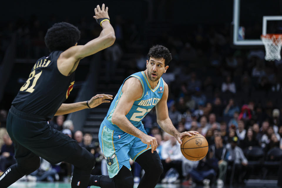 Charlotte Hornets guard Vasilije Micic, right, looks to pass against Cleveland Cavaliers center Jarrett Allen during the first half of an NBA basketball game in Charlotte, N.C., Wednesday, March 27, 2024. (AP Photo/Nell Redmond)