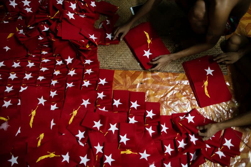 Workers prepare flags with the logo of Aung San Suu Kyi's National League for Democracy NLD party in Yangon