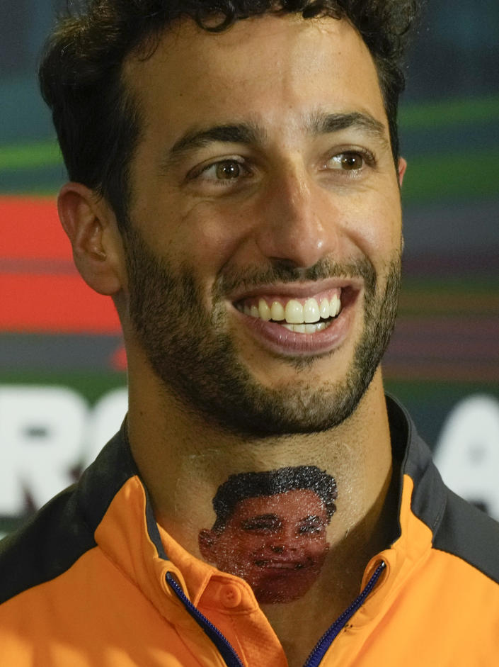 Mclaren driver Daniel Ricciardo of Australia shows a tattoo on his neck representing his teammate Lando Norris during a news conference at the Monza racetrack, in Monza, Italy, Thursday, Sept. 8, 2022. The Formula one race will be held on Sunday. (AP Photo/Luca Bruno)