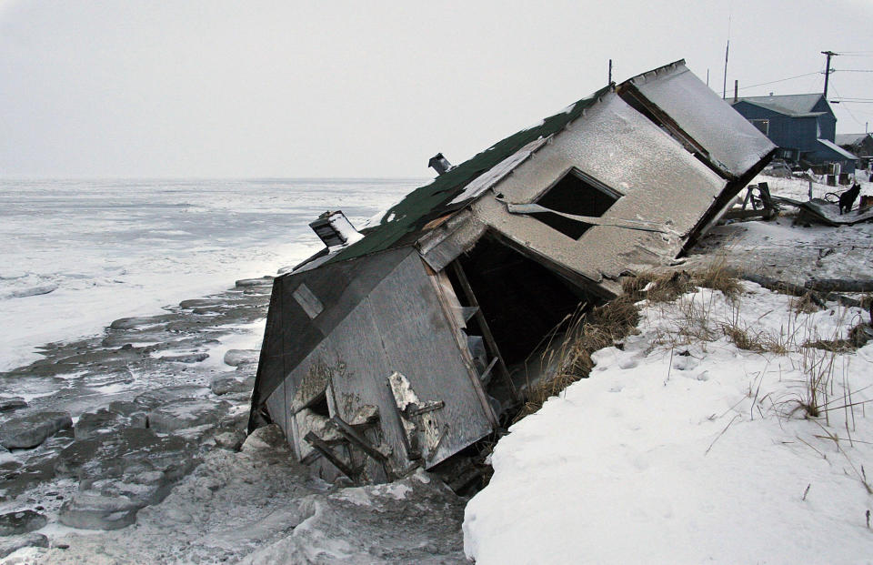 FILE - In this Dec. 8, 2006, file photo, Nathan Weyiouanna's abandoned house at the west end of Shishmaref, Alaska, sits on the beach after sliding off during a fall storm in 2005. Attorneys for 12 young Alaskans who sued over state climate change policy will argue their case before Alaska Supreme Court justices on Wednesday, Oct. 9, 2019. The lawsuit says state policy that promotes fossil fuels violates the constitutional right of young Alaskans to a safe climate. (AP Photo/Diana Haecker, File)