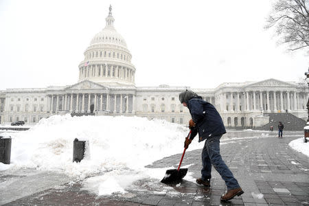 Aaron Rowe of the Architect of the Capitol's office, which is not affected by the partial government shutdown, shovels snow left by Winter Storm Gia, on the U.S. Capitol's plaza, in Washington, U.S., January 13, 2019. REUTERS/Mike Theiler