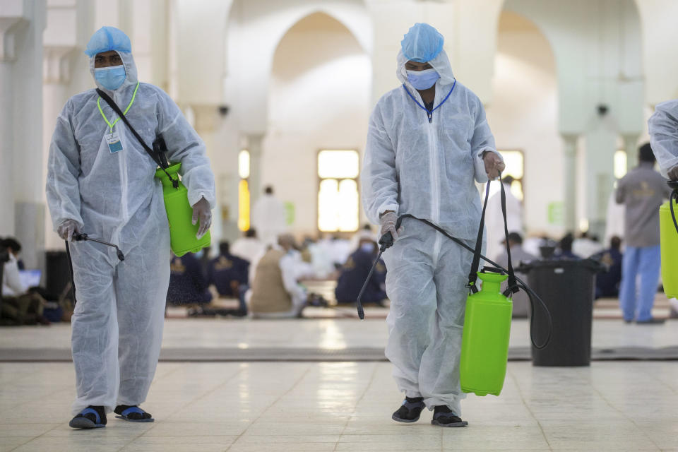 Health officials spray disinfectant inside the Namira Mosque in Arafat during the annual hajj pilgrimage near the holy city of Mecca, Saudi Arabia, Thursday, July 30, 2020. This year's hajj was dramatically scaled down from 2.5 million pilgrims to as few as 1,000 due to the coronavirus pandemic. (Saudi Ministry of Media via AP)