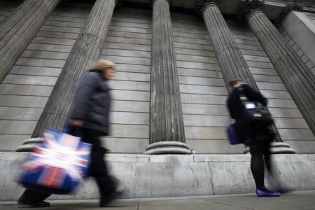 A woman carries a shopping bag decorated with a Union flag past the columns of the Bank of England in the City of London, July 3, 2012. REUTERS/Andrew Winning (BRITAIN - Tags: BUSINESS POLITICS) - RTR34JDM