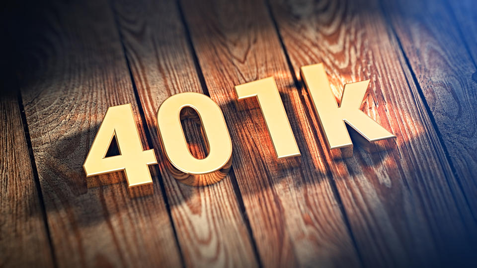 401k written out in gold block characters on top of a wooden plank background
