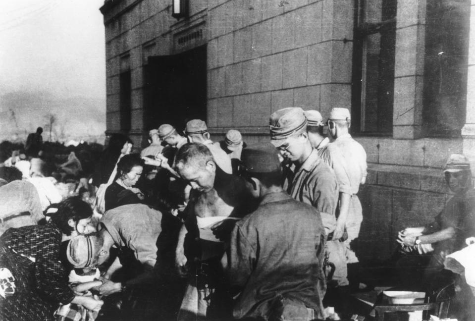 FILE - In this Aug. 6, 1945, file photo, survivors are seen as they receive emergency treatment by military medics shortly after the first atomic bomb ever used in warfare was dropped by the United States over Hiroshima, western Japan. Many people exposed to radiation developed symptoms such as vomiting and hair loss. Most of those with severe radiation symptoms died within three to six weeks. Others who lived beyond that developed health problems related to burns and radiation-induced cancers and other illnesses. (AP Photo, File)