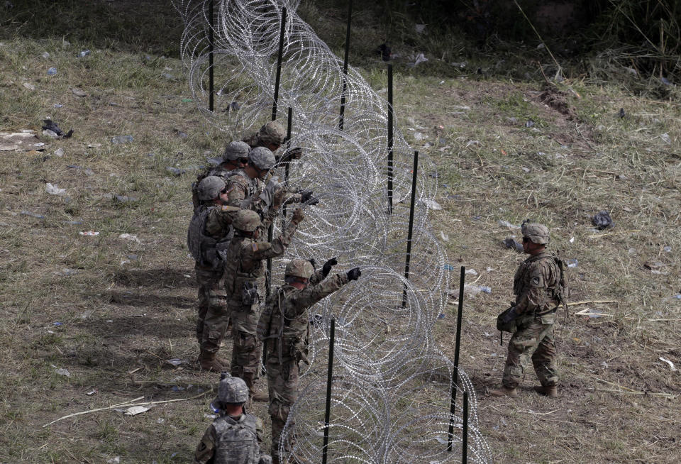 Members of the U.S.military place razor wire along the U.S.-Mexico border near the McAllen-Hidalgo International Bridge, Friday, Nov. 2, 2018, in McAllen, Texas. (AP Photo/Eric Gay)