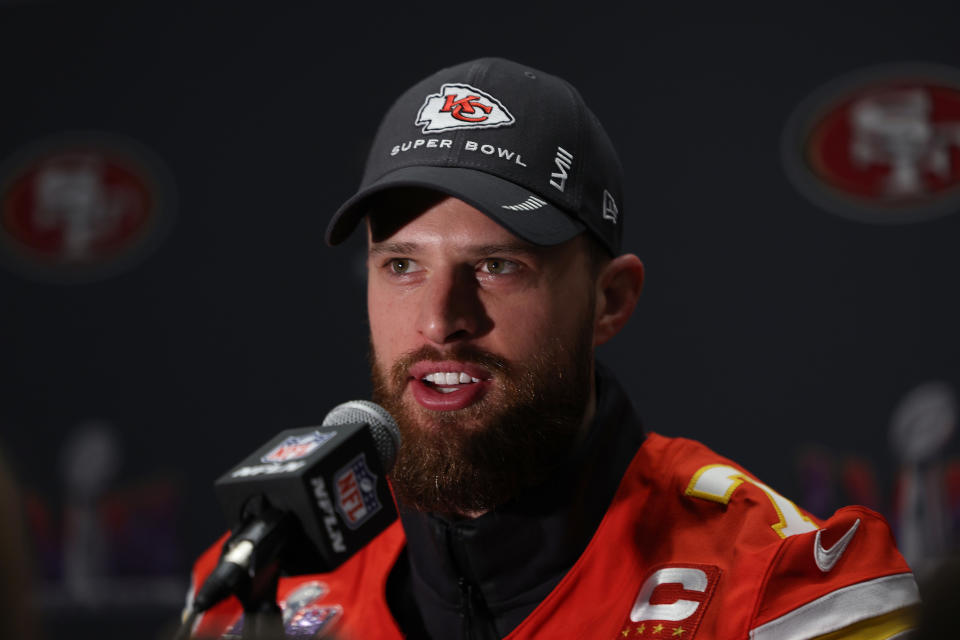 Harrison Butker in a Kansas City Chiefs uniform, with a Super Bowl cap, speaks at a press conference