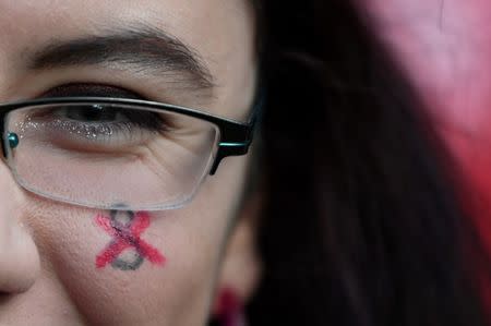 A demonstrator has a symbol for Repeal the 8th Amendment painted on her face during a march for more liberal Irish abortion laws in Dublin, Ireland, March 8, 2018. REUTERS/Clodagh Kilcoyne/Files
